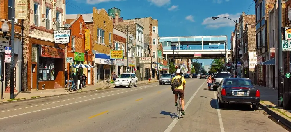 a man riding a bicycle on the street of Pilsen